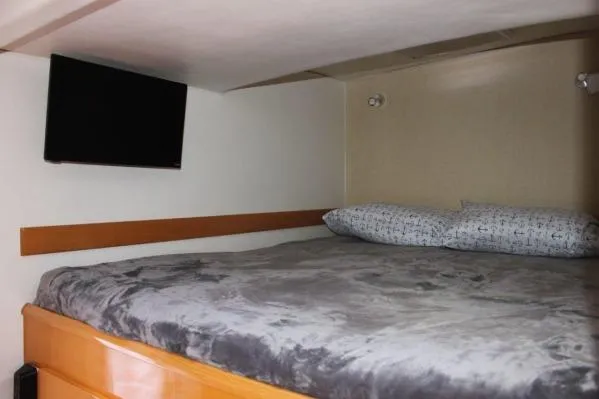 Jobsite Yacht Photos Pics Cozy cabin interior of 2006 Alliaura Marine Privilege 435 EZC with bed and wall-mounted TV.