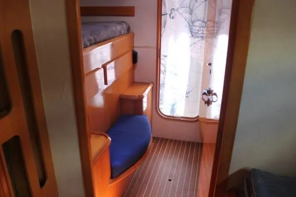 Jobsite Yacht Photos Pics Interior cabin of 2006 Alliaura Marine Privilege 435 EZC with wooden finish and blue seating.