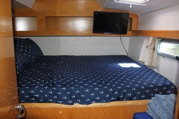 Jobsite Yacht Photos Pics 2006 Alliaura Marine Privilege 435 EZC cabin with bed, TV, and nautical-themed bedding.