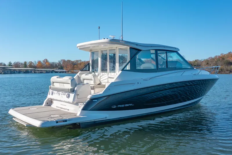  Yacht Photos Pics 2021 Regal 36 Grande Coupe boat on a serene lake.