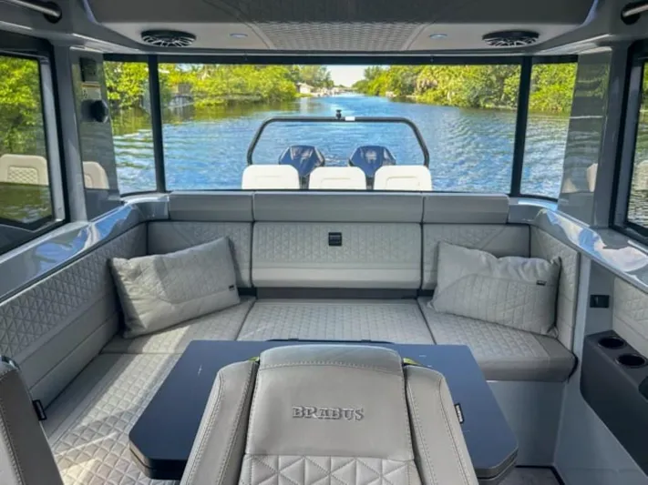  Yacht Photos Pics Luxurious interior of 2024 BRABUS Shadow 1000XC boat with plush seating and scenic water view.