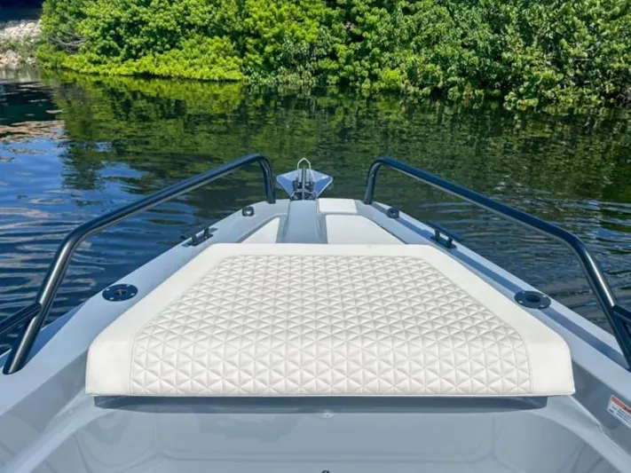 Yacht Photos Pics 2024 BRABUS Shadow 1000XC boat bow with quilted seating, surrounded by lush greenery.