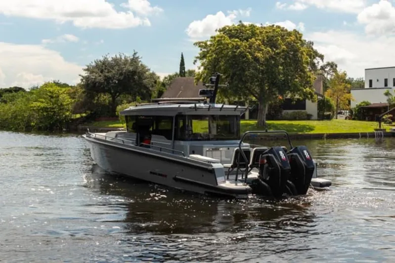  Yacht Photos Pics 2024 BRABUS Shadow 1000XC boat on a serene lake with lush greenery.