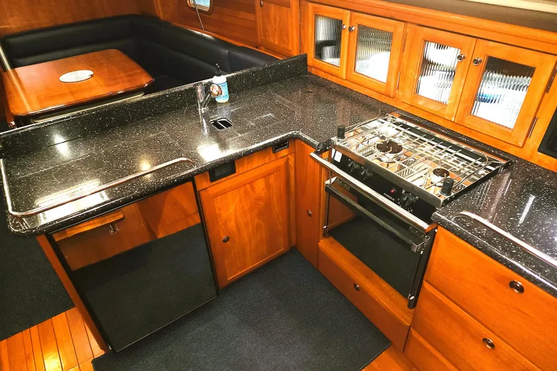 Antares Yacht Photos Pics Luxurious 2011 Hunter 39 yacht kitchen with sleek countertops and wooden cabinetry.