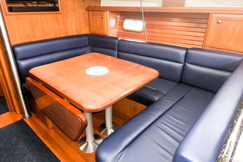 Antares Yacht Photos Pics Luxurious 2011 Hunter 39 yacht interior with blue leather seating and wooden dining table.