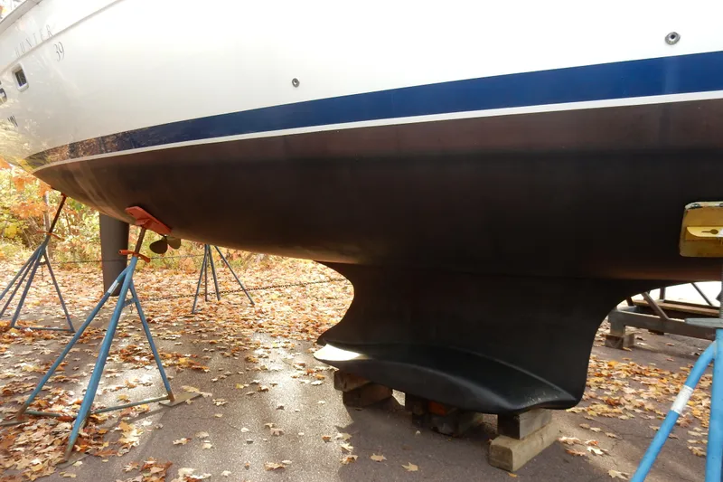 Antares Yacht Photos Pics 2011 Hunter 39 sailboat on stands, autumn leaves scattered on ground.