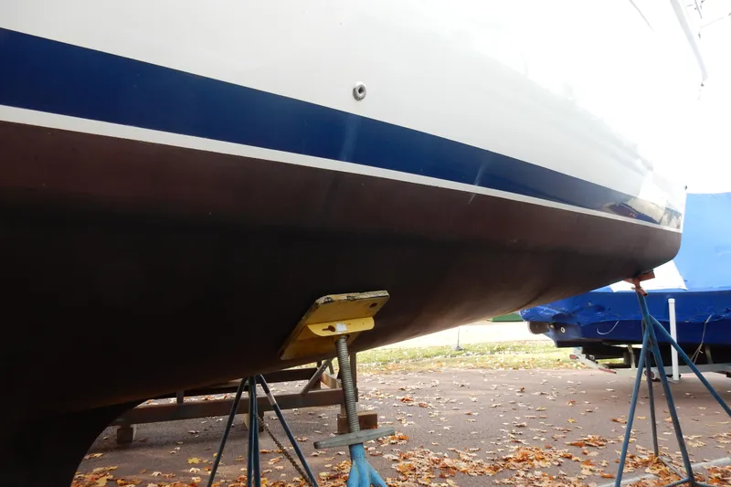 Antares Yacht Photos Pics 2011 Hunter 39 sailboat hull on stands, blue stripe, autumn leaves on ground.