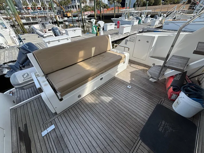 Sawbones Yacht Photos Pics 2015 Fairline Squadron 42 yacht deck with seating and storage, docked at marina.
