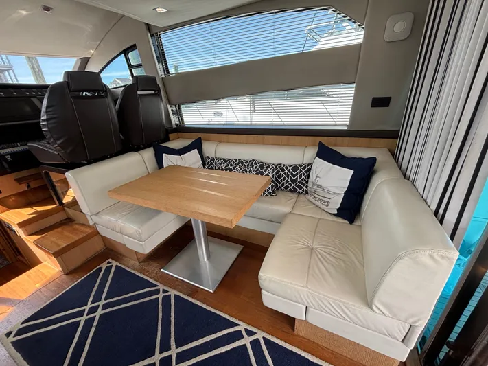 Sawbones Yacht Photos Pics Interior of 2015 Fairline Squadron 42 yacht with cozy seating and wooden table.