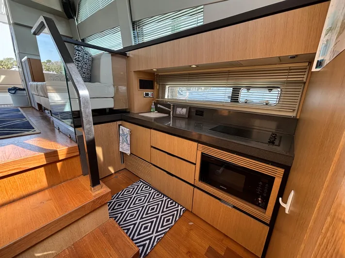Sawbones Yacht Photos Pics Modern kitchen interior of 2015 Fairline Squadron 42 yacht with wood cabinetry and appliances.