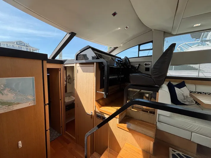 Sawbones Yacht Photos Pics Interior of 2015 Fairline Squadron 42 yacht, featuring helm and seating area.