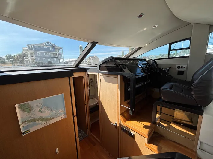 Sawbones Yacht Photos Pics Interior of 2015 Fairline Squadron 42 yacht, featuring helm station and wooden cabinetry.