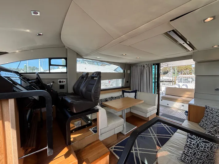 Sawbones Yacht Photos Pics Interior of 2015 Fairline Squadron 42 yacht, featuring modern seating and helm area.