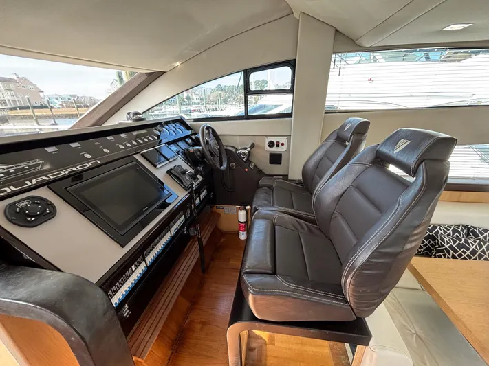 Sawbones Yacht Photos Pics Interior cockpit of 2015 Fairline Squadron 42 yacht with leather seats and control panel.