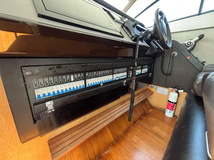 Sawbones Yacht Photos Pics Control panel of a 2015 Fairline Squadron 42 yacht with steering wheel and fire extinguisher.