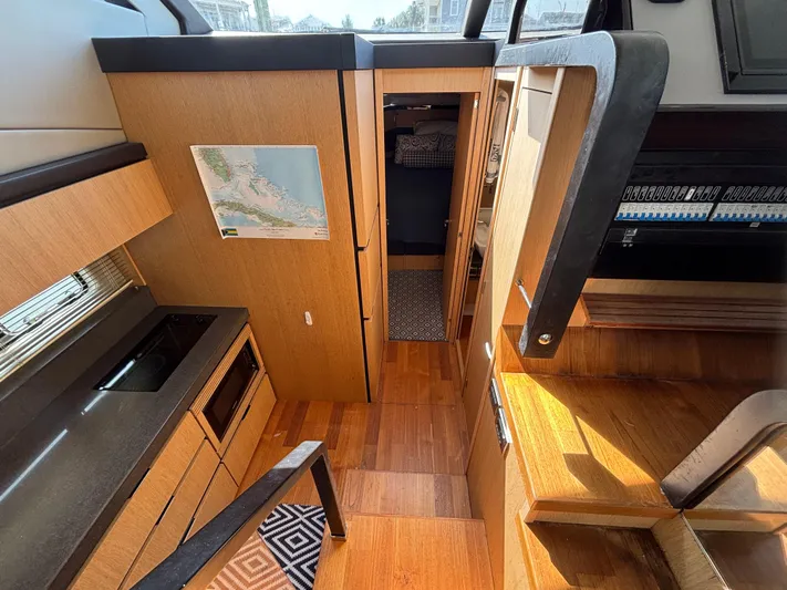 Sawbones Yacht Photos Pics Interior of 2015 Fairline Squadron 42 yacht, featuring modern kitchen and wooden flooring.