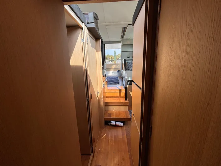 Sawbones Yacht Photos Pics Interior hallway of 2015 Fairline Squadron 42 yacht, featuring wooden finishes and natural light.