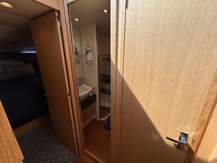 Sawbones Yacht Photos Pics Interior of 2015 Fairline Squadron 42 yacht, featuring a cozy cabin and bathroom.