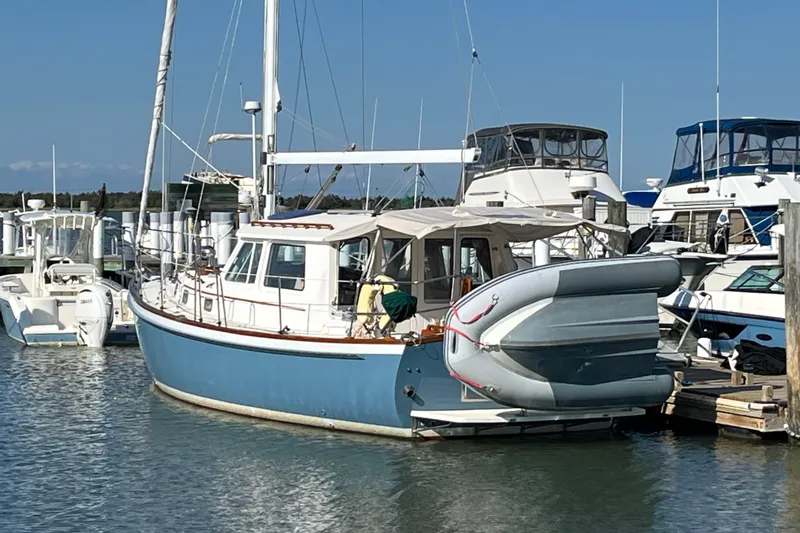 Spirit Yacht Photos Pics 2001 Cabo Rico Northeast 400 sailboat docked at marina with inflatable dinghy attached.