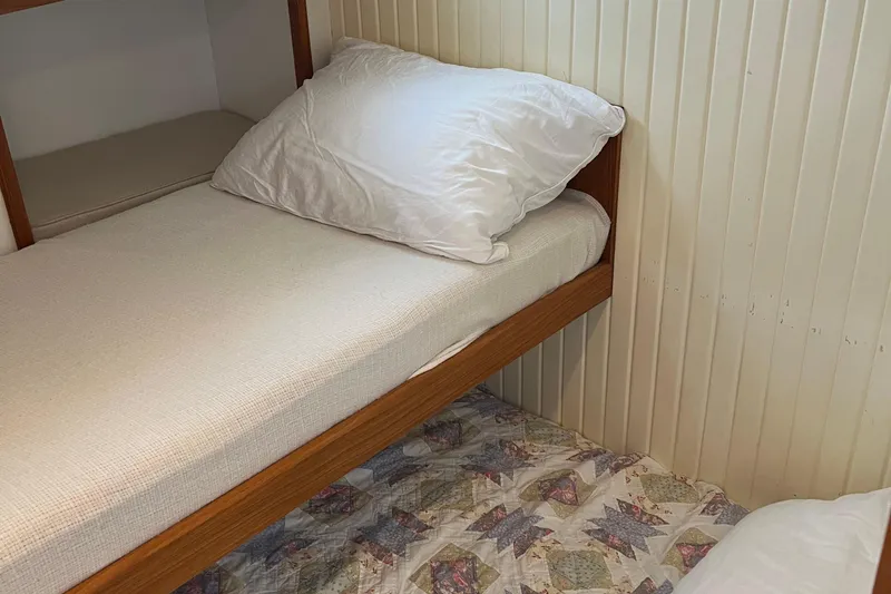 Spirit Yacht Photos Pics Bunk bed in 2001 Cabo Rico Northeast 400 yacht cabin, featuring white bedding and wooden frame.