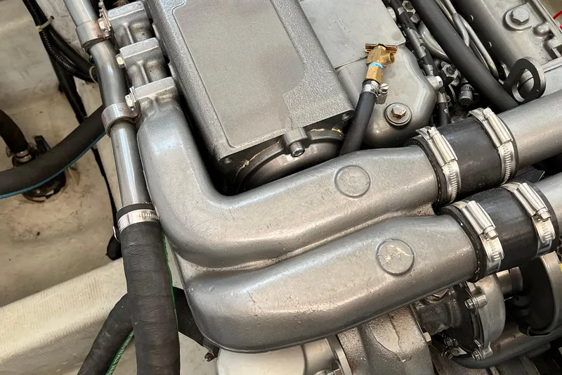 Spirit Yacht Photos Pics Engine components of a 2001 Cabo Rico Northeast 400 boat, featuring metal pipes and hoses.