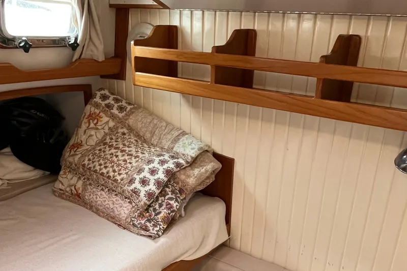 Spirit Yacht Photos Pics Cozy cabin interior of 2001 Cabo Rico Northeast 400 with wooden shelves and patterned pillows.