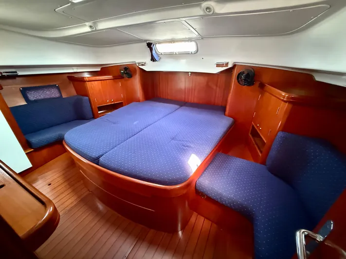 Southern Cross Yacht Photos Pics Luxurious cabin interior of 2003 Beneteau Oceanis 42CC with blue upholstery and wood finish.