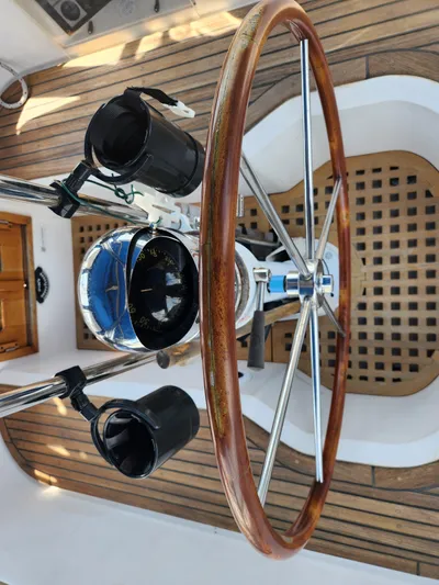 Lea Scotia Yacht Photos Pics Steering wheel and compass of a 1989 Taswell 43 sailboat, featuring wooden and metal elements.