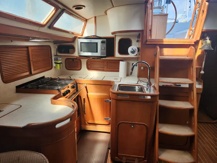 Lea Scotia Yacht Photos Pics Interior of 1989 Taswell 43 sailboat kitchen with wood cabinetry and modern appliances.