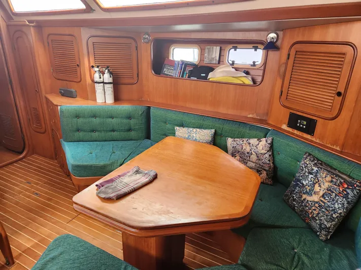 Lea Scotia Yacht Photos Pics Cozy interior of 1989 Taswell 43 sailboat with green seating and wooden table.