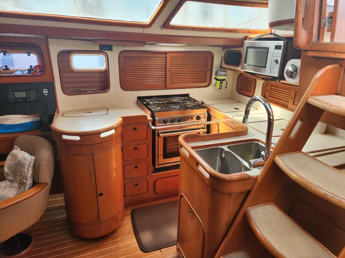 Lea Scotia Yacht Photos Pics Interior of 1989 Taswell 43 yacht kitchen with stove, sink, and wooden cabinetry.