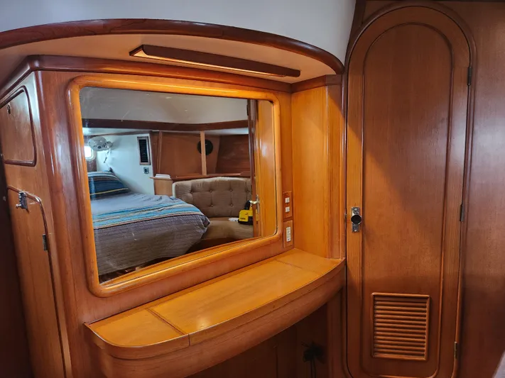 Lea Scotia Yacht Photos Pics Interior of 1989 Taswell 43 yacht with wooden cabinetry and mirror reflecting cozy bedroom.