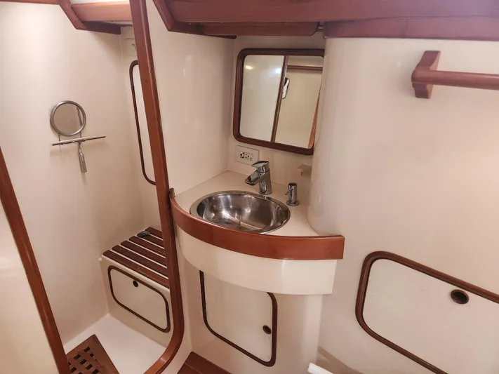 Lea Scotia Yacht Photos Pics 1989 Taswell 43 yacht bathroom with sink, mirror, and wooden accents.