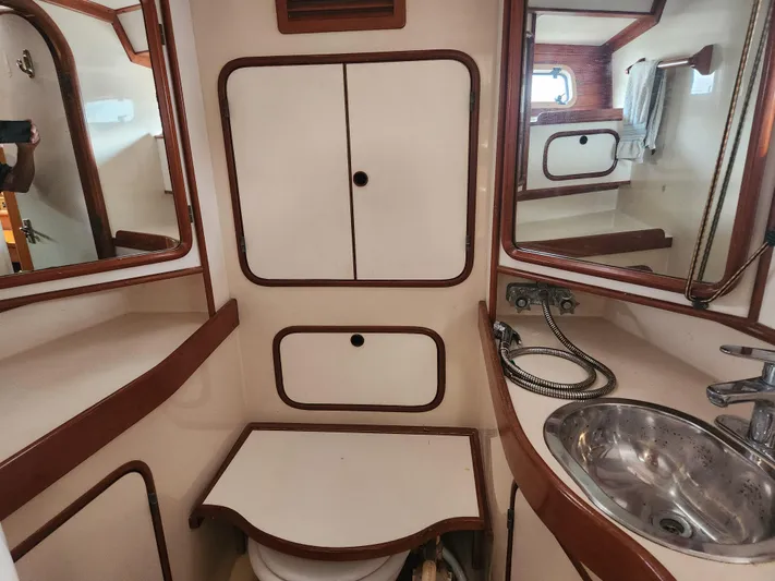 Lea Scotia Yacht Photos Pics Interior of 1989 Taswell 43 yacht bathroom with sink, mirrors, and storage cabinets.