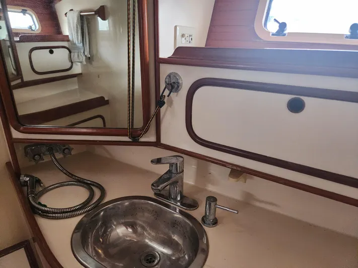 Lea Scotia Yacht Photos Pics Bathroom sink area in a 1989 Taswell 43 yacht, featuring a mirror and porthole.