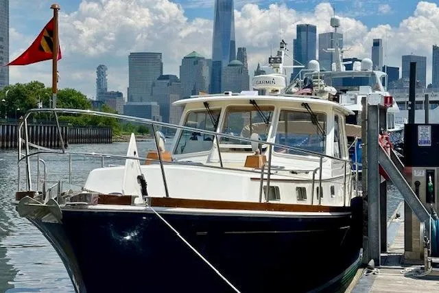 No Rules Yacht Photos Pics 2003 Grand Banks Eastbay 43 HX docked with city skyline in background.