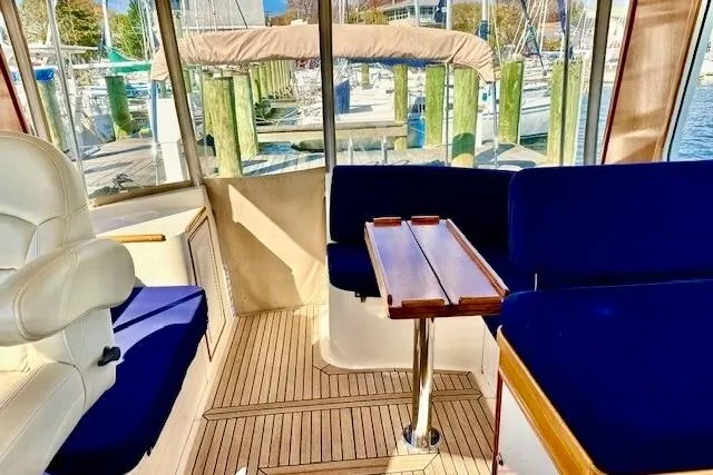 No Rules Yacht Photos Pics Interior of 2003 Grand Banks Eastbay 43 HX yacht with blue seating and wooden table.
