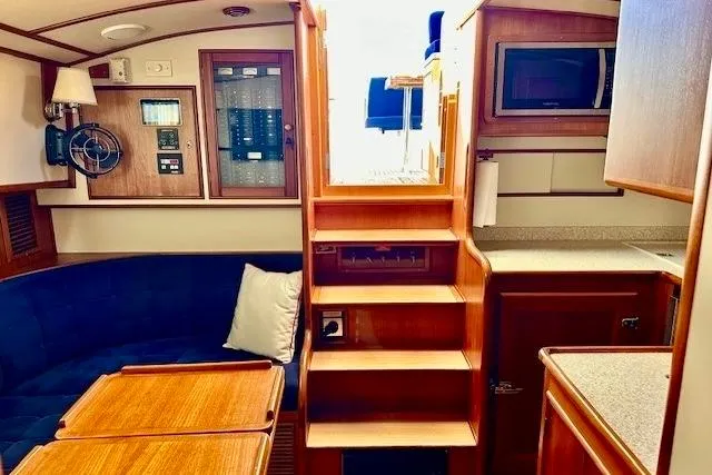 No Rules Yacht Photos Pics Interior of 2003 Grand Banks Eastbay 43 HX yacht, featuring wooden cabinetry and seating area.