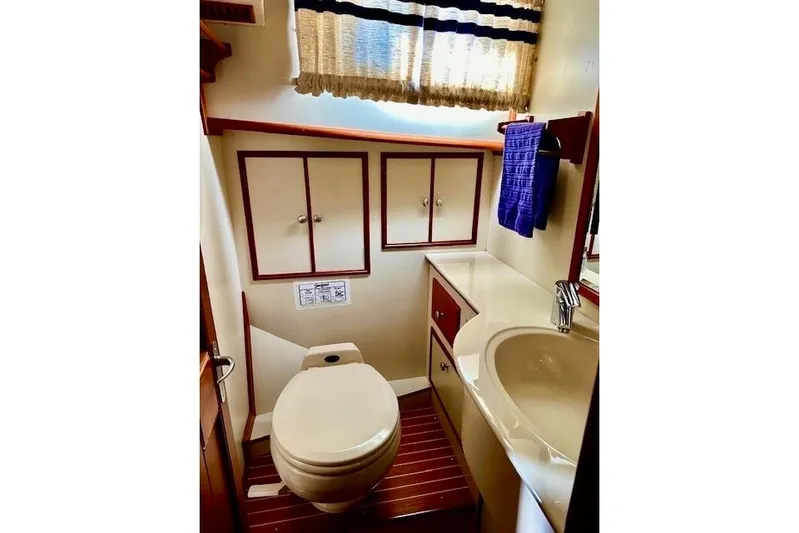 No Rules Yacht Photos Pics Bathroom interior of 2003 Grand Banks Eastbay 43 HX yacht, featuring sink and toilet.