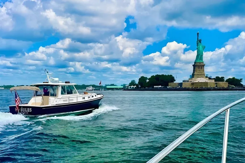 No Rules Yacht Photos Pics 2003 Grand Banks Eastbay 43 HX cruising near Statue of Liberty under blue sky.