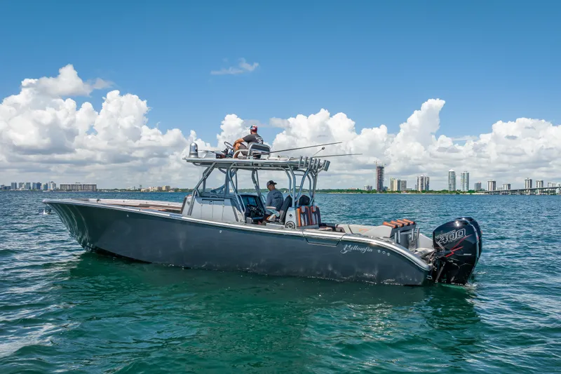  Yacht Photos Pics 2012 Yellowfin 39 boat on water, clear sky, city skyline in background.