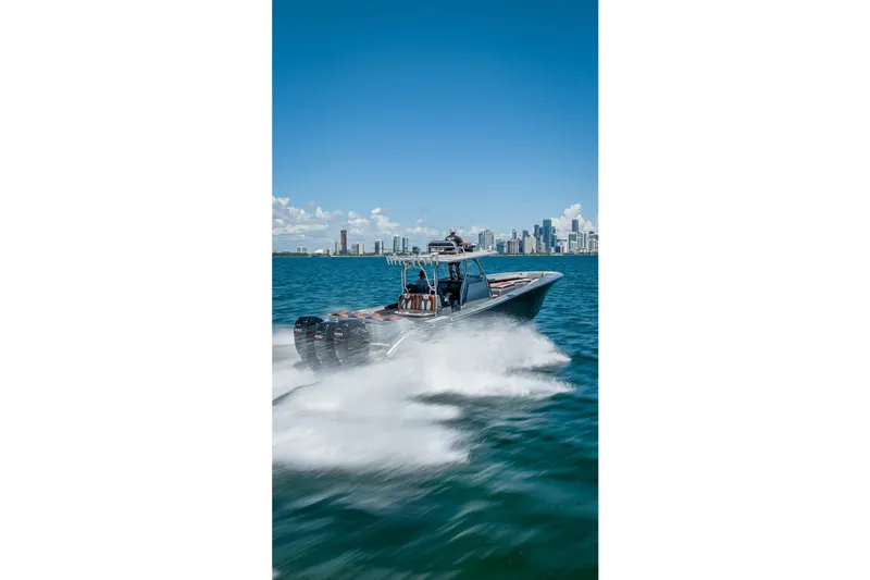  Yacht Photos Pics 2012 Yellowfin 39 boat speeding on water with city skyline in background.