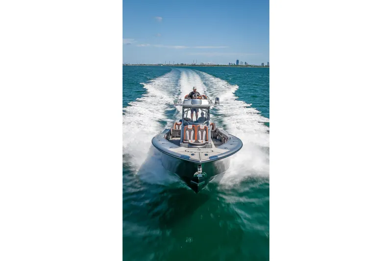  Yacht Photos Pics 2012 Yellowfin 39 boat cruising on open water with city skyline in background.
