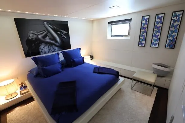 Tribu Yacht Photos Pics Luxurious Mondomarine Explorer 2007 yacht bedroom with blue bedding and modern decor.