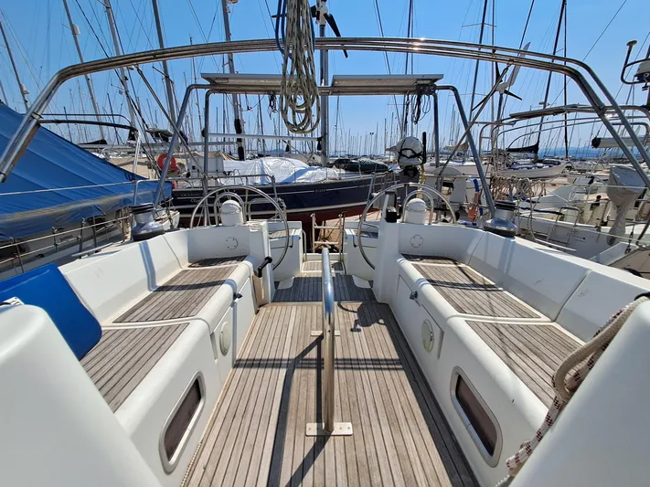 Nemesis Yacht Photos Pics 2005 Beneteau Oceanis 473 sailboat cockpit with wooden deck, docked in a marina.