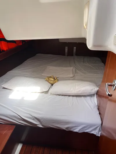 Nemesis Yacht Photos Pics Cozy cabin interior of 2005 Beneteau Oceanis 473 sailboat with neatly arranged bedding.