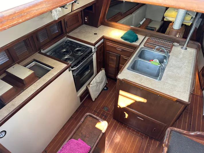 Lagniappe Yacht Photos Pics Interior of 1990 Pacific Seacraft Crealock 44 yacht, featuring a compact kitchen with stove and sink.