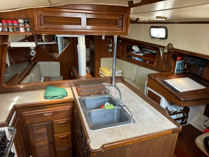 Lagniappe Yacht Photos Pics Interior of 1990 Pacific Seacraft Crealock 44 yacht with kitchen and seating area.