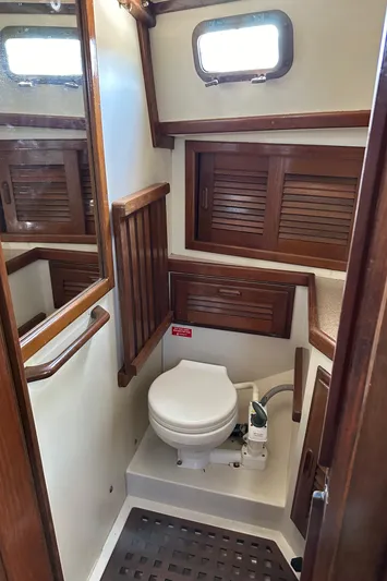 Lagniappe Yacht Photos Pics 1990 Pacific Seacraft Crealock 44 yacht bathroom with wooden accents and porthole window.