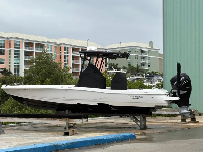  Yacht Photos Pics 2023 Caymas 28 HB boat on a dock, with modern buildings in the background.
